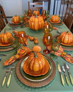 a table set for thanksgiving with pumpkins on it