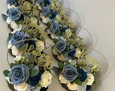 cupcakes decorated with blue and white flowers are arranged in the shape of a heart