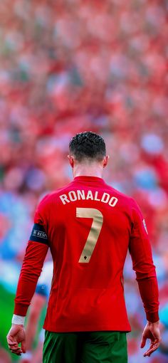 a man in red jersey standing on soccer field