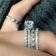 a woman's hand with three rings on it and a diamond ring in the middle