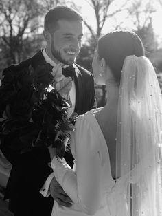 the bride and groom are standing together outside