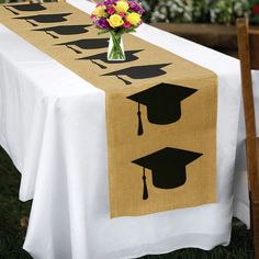 a table topped with a white table cloth covered in graduation decorations