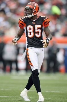 the football player is wearing an orange and black uniform with numbers on it's chest