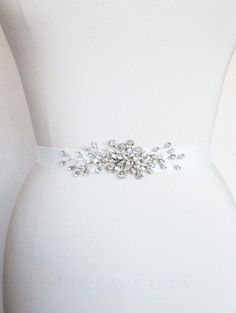 "This petite belt features elegant Swarovski crystal design appliquéd on a grosgrain ribbon sash. The crystal part of the sash measures about 5\" long and 1 1/2\" wide. The ribbon measures 1\" wide and 150\" long. Available is gold or silver finish and a variety of ribbon options. - For the photo of the grossgrain ribbon color options, please take a look here: https://www.etsy.com/listing/231071205/grosgrain-ribbon-swatches-ribbon-color?ref=shop_home_active_18 - For the photo of the satin ribbon Elegant Silver Belt With Rhinestones, Elegant White Sashes With Rhinestones, White Crystal Bridal Belt For Party, Fitted Silver Bridal Belt With Sashes, Elegant White Belt With Rhinestones, Elegant Silver Embroidered Belt, Elegant Adjustable Embellished Bridal Belt, Elegant Embellished Adjustable Bridal Belt, White Crystal Sash For Formal Occasions