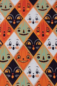 an orange, black and green pattern with faces on it