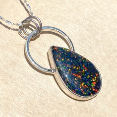 Kyocera Opal handcrafted into a cabochon and placed in a customized sterling silver bezel setting. Includes an 18 inch, solid sterling silver 1.2mm serpentine chain. Pendant measures 0.8" x 1.5" and the cabochon is approximately 16 x 24mm. Sterling Silver Large Round Pendant Jewelry, Nickel-free Sterling Silver Pendant Necklace, Nickel-free Sterling Silver Custom Pendant Necklace, Custom Sterling Silver Pendant Necklace, Nickel-free, Custom Sterling Silver Pendant Necklace, Nickel Free, Sterling Silver Jewelry With Polished Snake Chain, Sterling Silver Jewelry With Large Pendant, Sterling Silver Snake Chain Jewelry With Polished Finish, Silver Cabochon Jewelry For Memorial