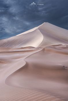 an image of a desert landscape with clouds in the sky and sand dunes on the ground