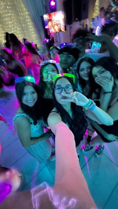 a group of young women standing next to each other in front of a neon light