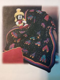 a mickey mouse blanket on top of a bed