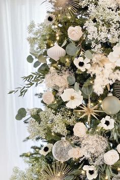 a christmas tree decorated with white flowers and greenery