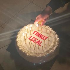 a person lighting candles on a cake with the words small legal written on it in red