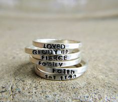 "Skinny sterling silver rings are just the right width to hold a name, a word, or a thought as a reminder on your finger. Because they are so narrow you can easily stack them with other words or names or with any decorative rings. This listing is for ONE 2mm stamped ring. I have both upper and lowercase letters and numbers in this simple font. Make sure you include your text in the box at check out exactly as you would like it to appear on the ring. These are all hand stamped which adds to their Personalized Silver Ring With Meaningful Style, Inspirational Personalized Sterling Silver Rings, Inspirational Hand Stamped Silver Rings, Personalized Meaningful Sterling Silver Rings, Meaningful Personalized Sterling Silver Rings, Meaningful Silver Stackable Rings, Personalized Sterling Silver Engraved Ring, Personalized Inspirational Ring Jewelry, Inspirational Personalized Ring Jewelry