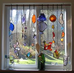 a window with many different colored glass items hanging from it