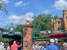 the entrance to disneyland california adventure park with people walking around and onlookers