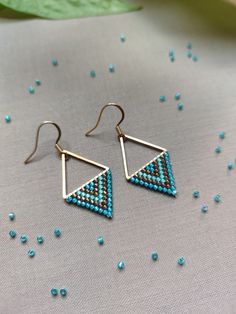 Dive into the bliss of summer with our 'Aegean Breeze Triangle Earrings'. Handcrafted with love and precision, each earring features a Stainless Steel Gold link that anchors a refreshing blend of turquoise blue, aqua blue, and bronze Miyuki beads. Utilizing the ancient technique of bead weaving, specifically brick stitch, this design mirrors the allure of ocean waves and the warmth of summer skies. Mirroring the allure of ocean waves and the warmth of summer skies these triangle earrings elevate Blue Triangle Earrings For Gift, Tiny Beads Drop Earrings For Gifts, Bohemian Earrings With Dangling Beads For Everyday, Minimalist Earrings With Dangling Beads As Gift, Bohemian Everyday Earrings With Dangling Beads, Handmade Minimalist Beaded Earrings For Gift, Adjustable Geometric Beaded Jewelry, Minimalist Sterling Silver Earrings For Summer, Bohemian Triangle Adjustable Earrings