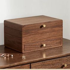 a wooden box sitting on top of a table next to some glasses and a pair of eyeglasses