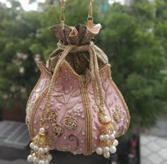 a pink purse hanging from the side of a tree