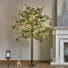 a lighted tree in a living room next to a fire place and clock on the floor