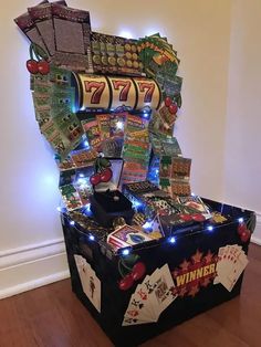 a casino machine with lots of cards and lights on it's sides, sitting in a room