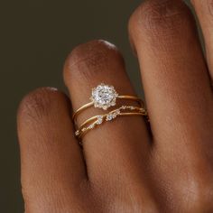 a woman's hand with two gold rings on her left and one diamond ring on the right