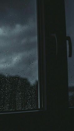 a window with raindrops on it and the sky in the backround