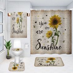 a bathroom with sunflowers on the shower curtain, rug and toilet in it