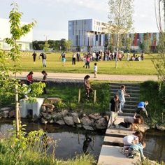 children are playing in the water near a park with stairs leading up to some buildings