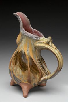 a brown and white ceramic pitcher on a gray background