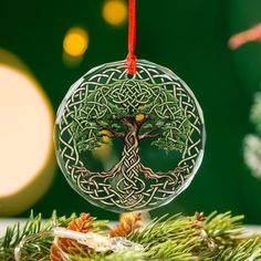 a glass ornament with a tree on it