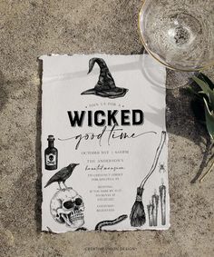 a paper with a witches theme on it next to a wine glass and some plants