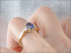 This classic ring is timeless and elegant, a three stone style that has been popular for centuries, and will remain fashionable for years more to come. The beauty of this style of ring is the focus it gives the stones - there's no distracting from their luxurious sparkle! We've set this ring with one of our finest sapphires. Originating in Sri Lanka, we chose this Ceylon Sapphire personally during one of our frequent gem buying trips. The color is perfection, a rich cobalt blue that is considere Elegant Three Stone Sapphire Ring, Timeless Three Stone Sapphire Ring, Classic Three Stone Jewelry For Proposal, Elegant Three Stone Round Cut Sapphire Ring, Classic Sapphire Three Stone Rings, Elegant Three Stone Sapphire Ring In Yellow Gold, Classic Sapphire Ring For Proposal, Luxury Three Stone Sapphire Promise Ring, Elegant Three Stone Yellow Gold Sapphire Ring