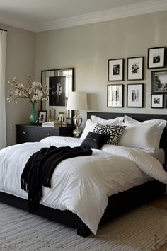 a bedroom with white bedding and black accents