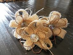 some burlap flowers sitting on top of a wooden table