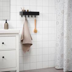 a bathroom with a sink, mirror and towel rack on the wall next to it