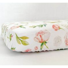 an image of a floral print pillow on a white tablecloth with pink flowers and green leaves