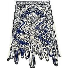 a blue and white area rug with an intricate design on the bottom, in front of a