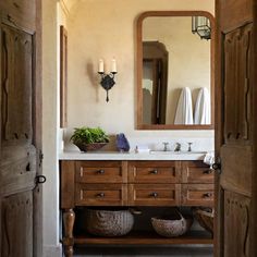 a bathroom with wooden cabinets and a large mirror