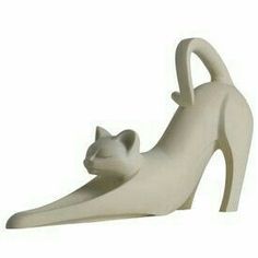 a white cat statue sitting on top of a high heel shoe with its tail curled up