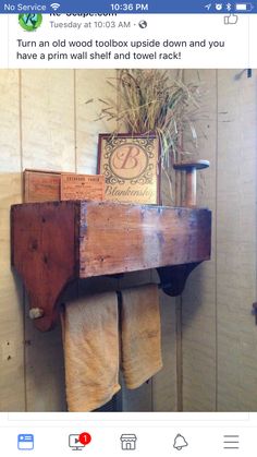 an old wooden shelf with towels hanging from it's sides and a sign on top