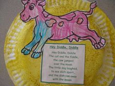 a yellow paper plate with a pink dog on it's side and a blue ribbon around its neck