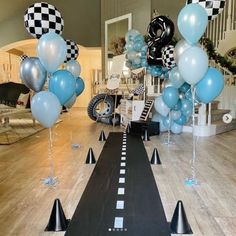 balloons and streamers are set up on the floor for a race themed birthday party