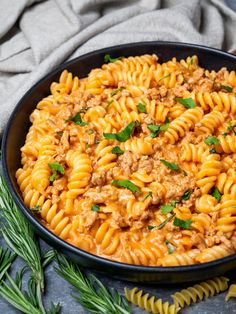 an easy ground turkey pasta dish in a black bowl with herbs on the side and text overlay that says easy ground turkey pasta