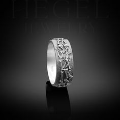 a silver ring with an image of a woman holding a cross on it's side