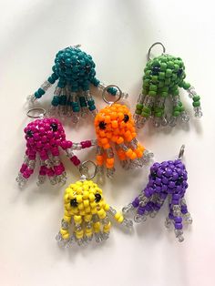 six beaded key chains are arranged in different colors and sizes, each with an individual's face