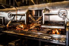 an industrial kitchen with lots of burners on the stove and ovens in it