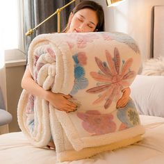 a woman laying on top of a bed under a blanket