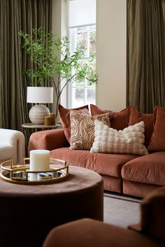 a living room filled with lots of furniture and pillows on top of a brown couch