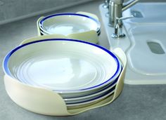 a stack of blue and white plates next to a sink