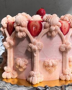 a pink cake with white frosting and strawberries on top