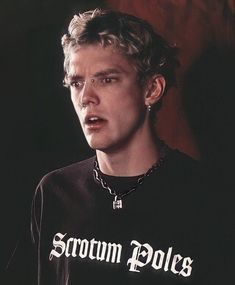 a young man wearing a black shirt with white writing on it